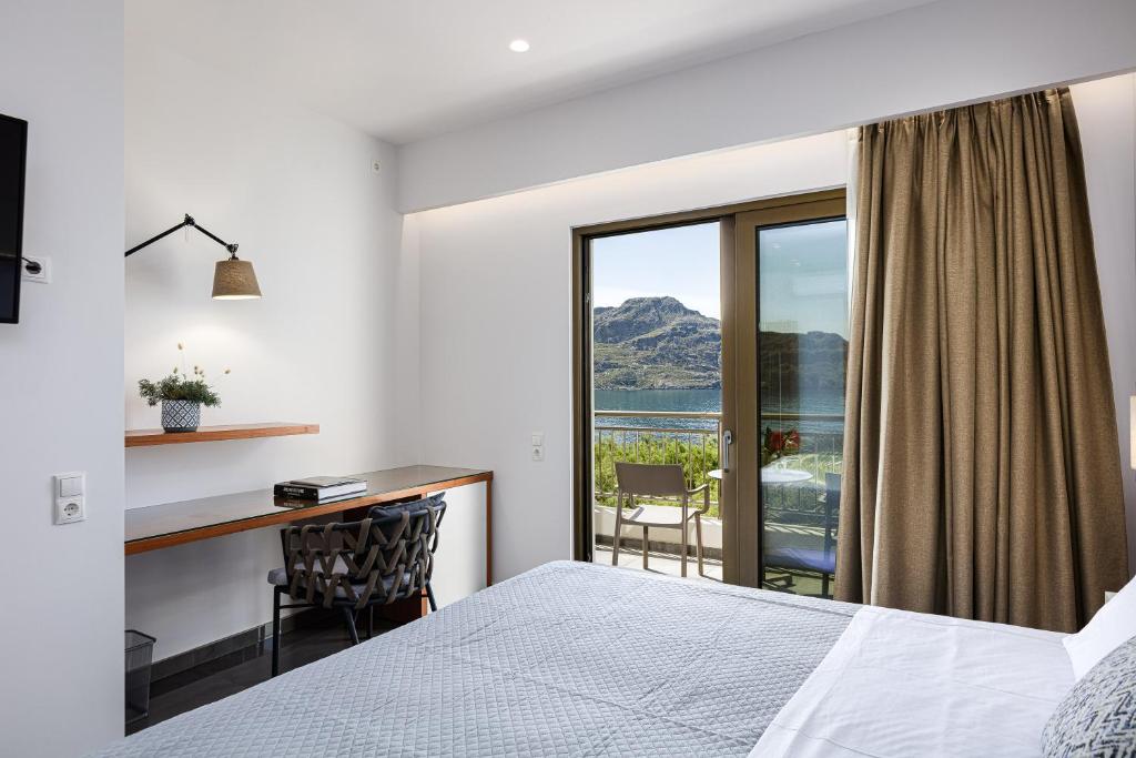 a bedroom with a bed and a desk and a window at Artemis Exclusive Double Sea View Adults Only in Plakias