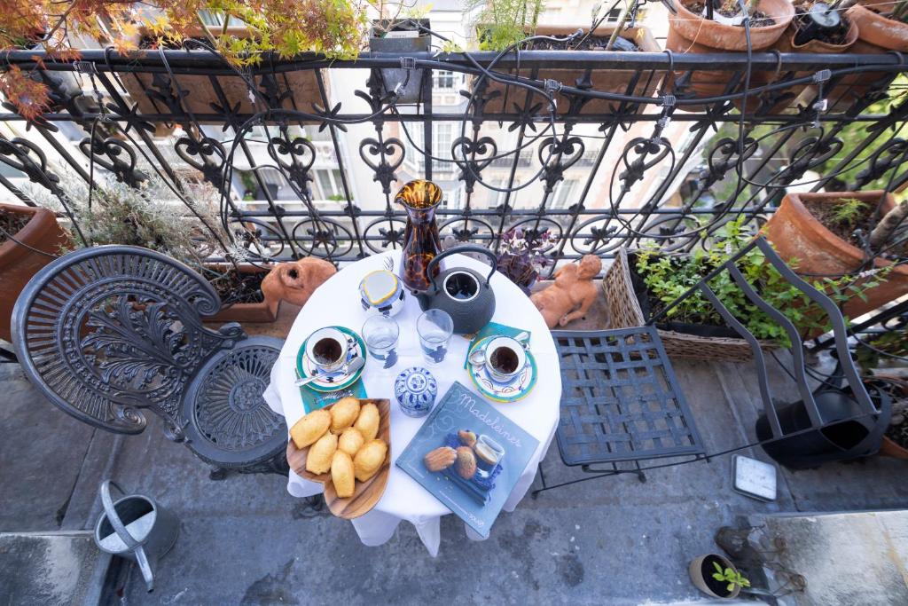 a table with a plate of food on a balcony at MaisondesChaumes-Paris in Paris