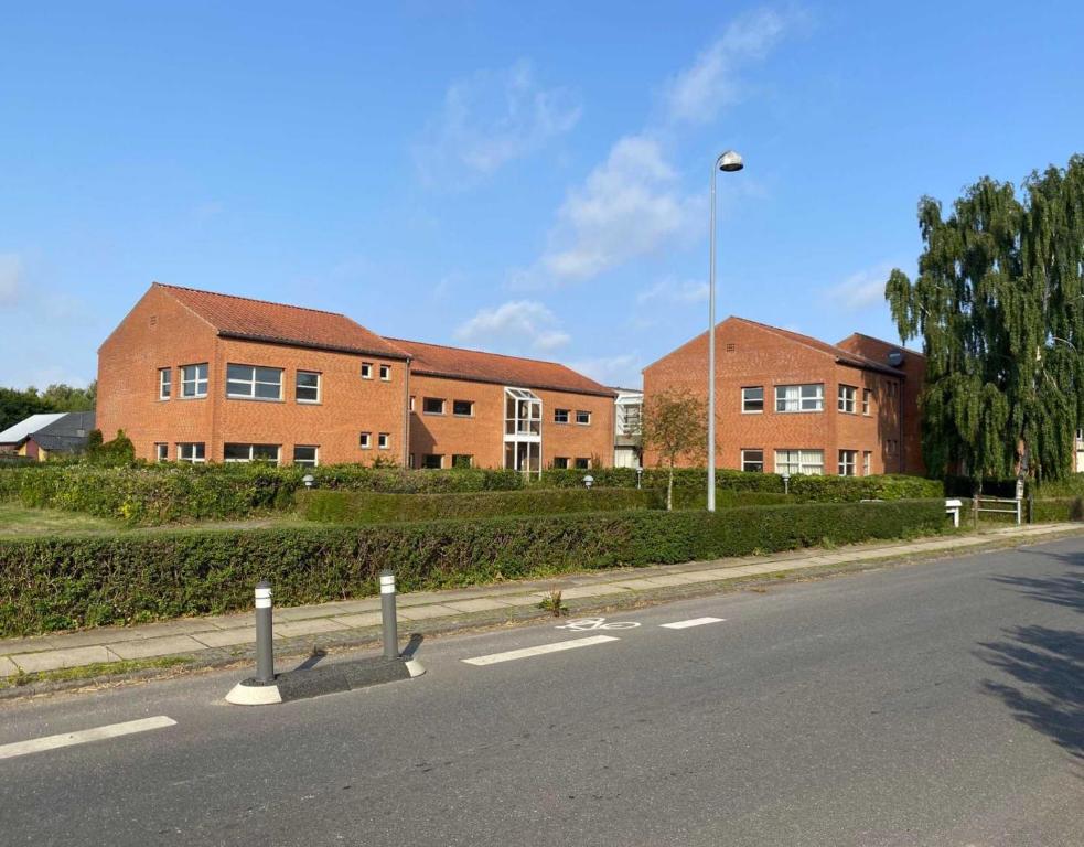 une rue vide devant un bâtiment en briques dans l'établissement Djurs Housing, à Trustrup