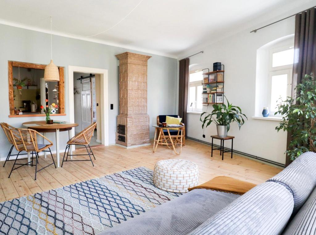 een woonkamer met een bank en een tafel bij Ferienwohnung Gustav Kaiser Apartment - 60qm Design Fewo Zittauer Gebirge - Unterkunft in historischer Altstadt im Dreiländereck in Zittau