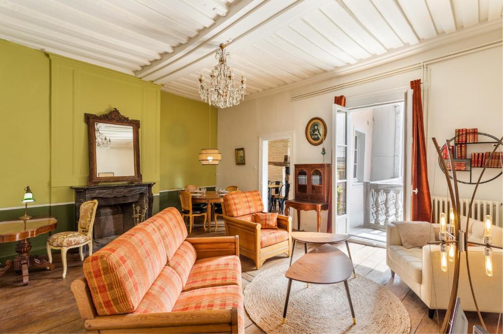een woonkamer met een bank en een open haard bij Dame de Coeur - Appartement spacieux en plein centre historique in Rennes
