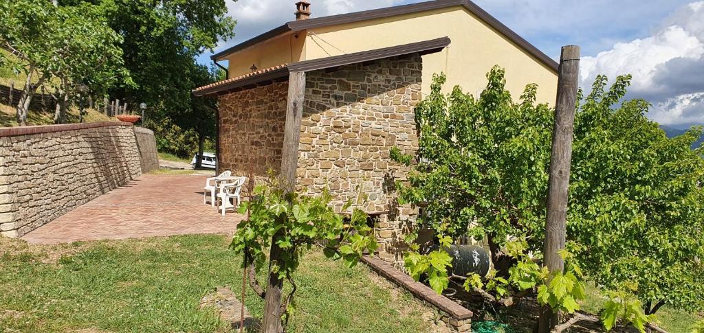 a stone building with a table and a chair in a yard at Casa vacanze Le Fontane in Orria