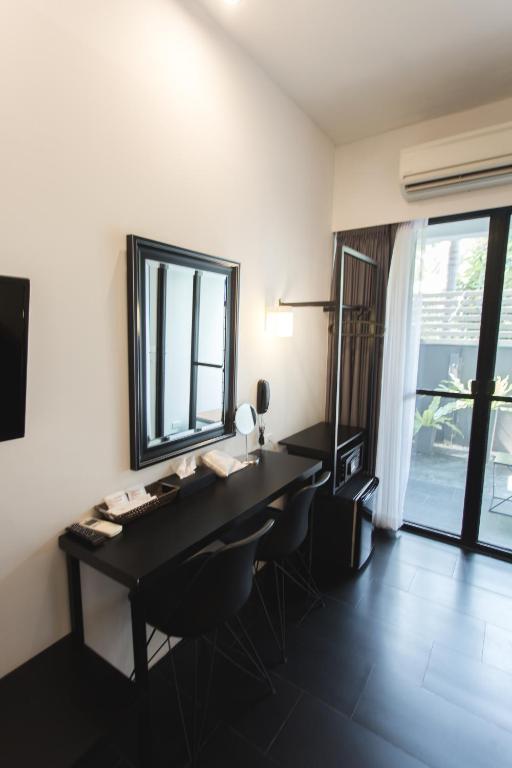 A long wall-mounted desk beside a glazed doorway or window, with two chairs.