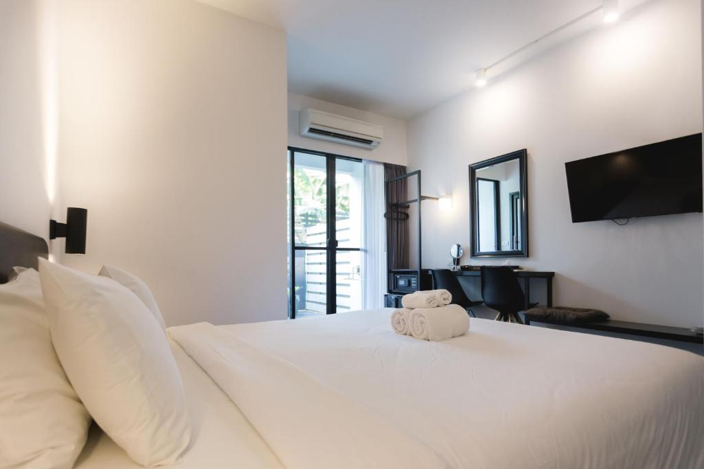 A double room with a large bed, wall-mounted television, desk and glazed opening.