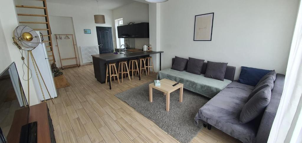 a living room with a couch and a table at LFA La petite maison du coin in Flémalle-Grande