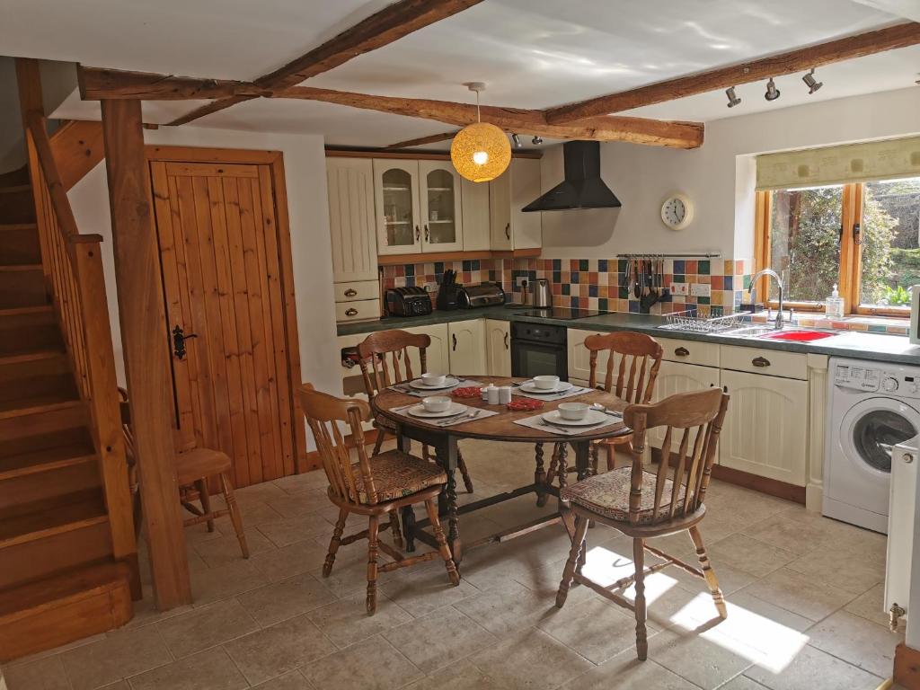 a kitchen with a table and chairs in a kitchen at Lupin Cottage at Boningale Manor in Wolverhampton