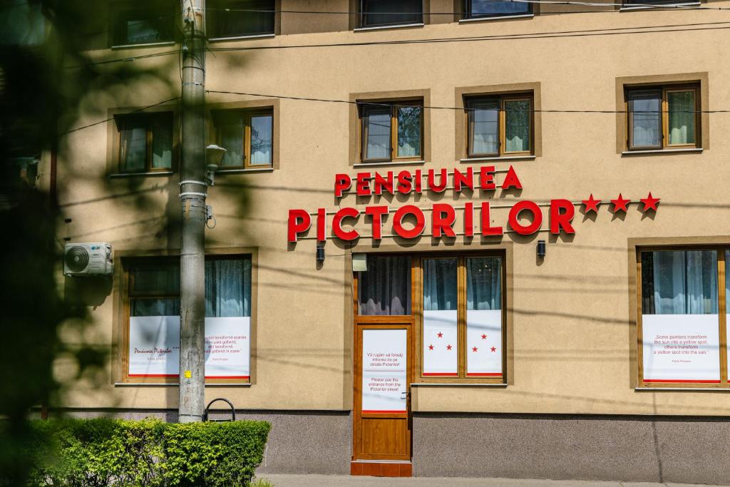 un edificio con un letrero para un practicante de impresión en Pensiunea Pictorilor en Baia Mare