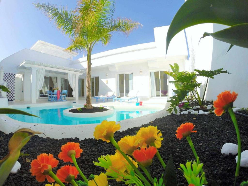Villa con piscina y patio con flores en Casa Nature by Vacanzy Collection, en Corralejo