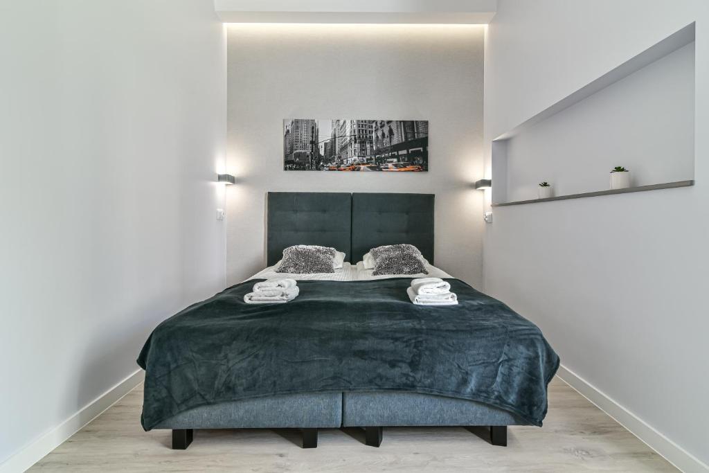 ein Schlafzimmer mit einem großen Bett und einer grünen Decke in der Unterkunft LTC Apartments Haffnera in Sopot
