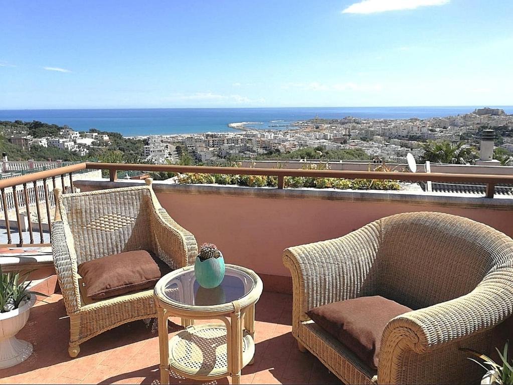 two wicker chairs and a table on a balcony at Villa Arenella in Vieste