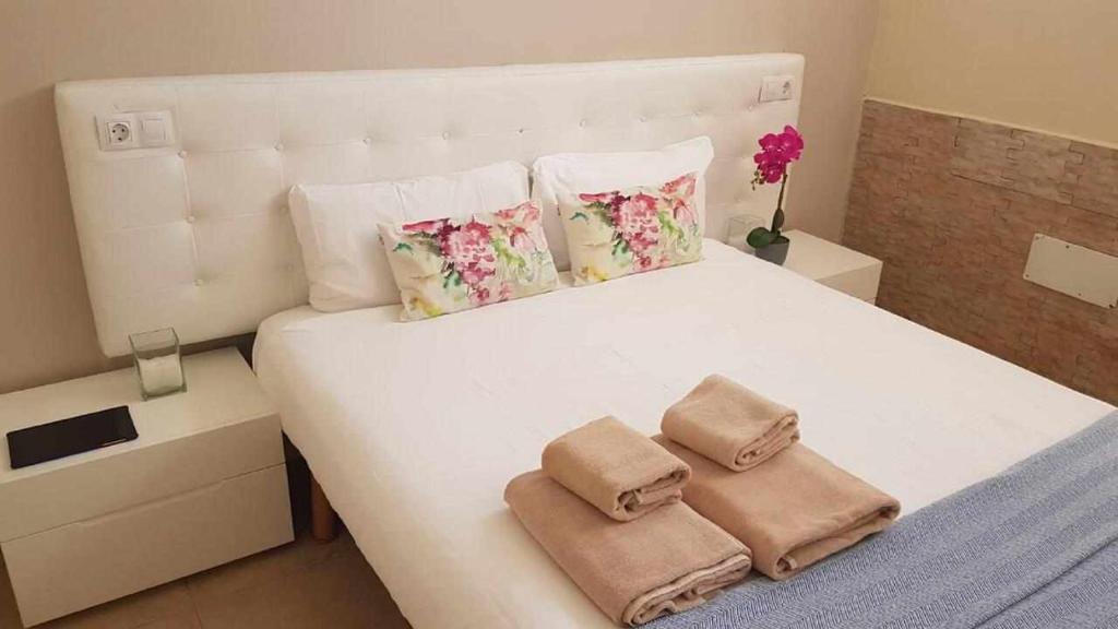 um quarto com uma cama branca e 2 almofadas em Apartamento Ocean em Corralejo