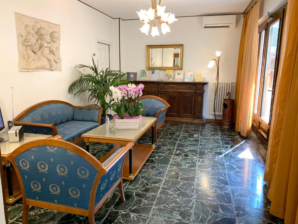a living room with couches and a table with flowers at Hotel Villa Margherita in Limone sul Garda