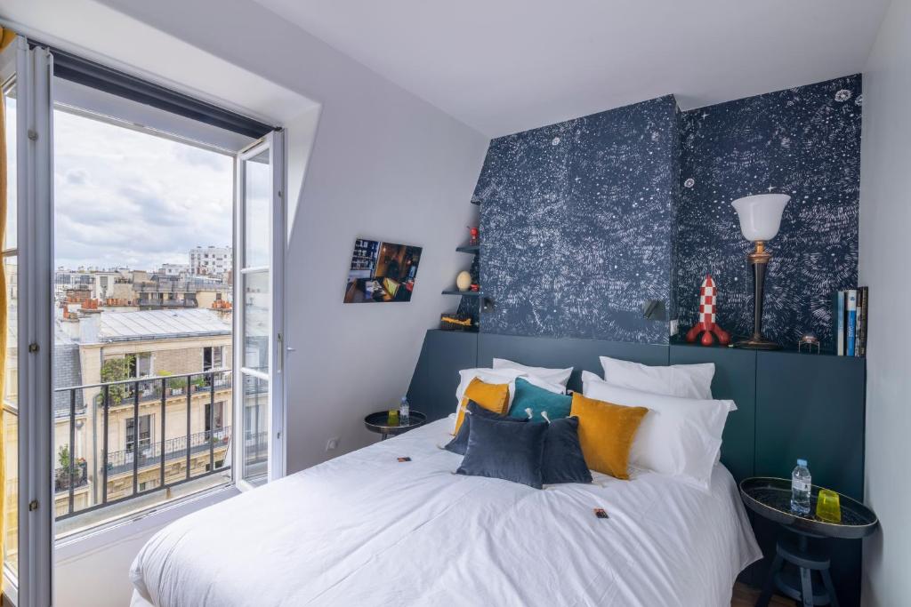 Un dormitorio con una cama grande y una ventana en MaisondesChaumes-Paris en París