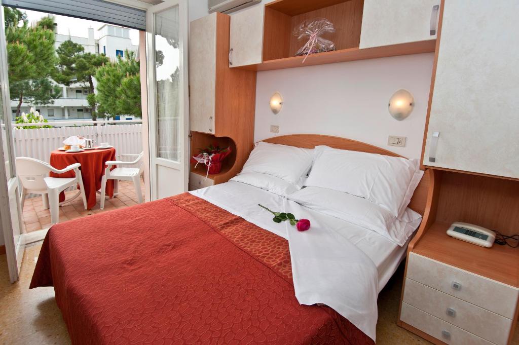ミラノ・マリッティマにあるHotel Cheryのベッドルーム1室(赤毛布付きの大型ベッド1台付)
