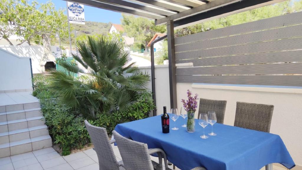 a blue table with wine glasses on a patio at Apartments Riba in Vis