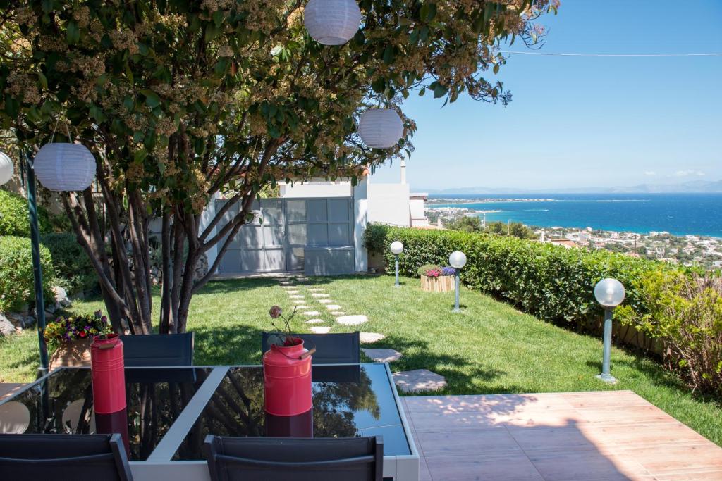 a patio with a view of the ocean at Harris elegant house superb view near airport in Artemida