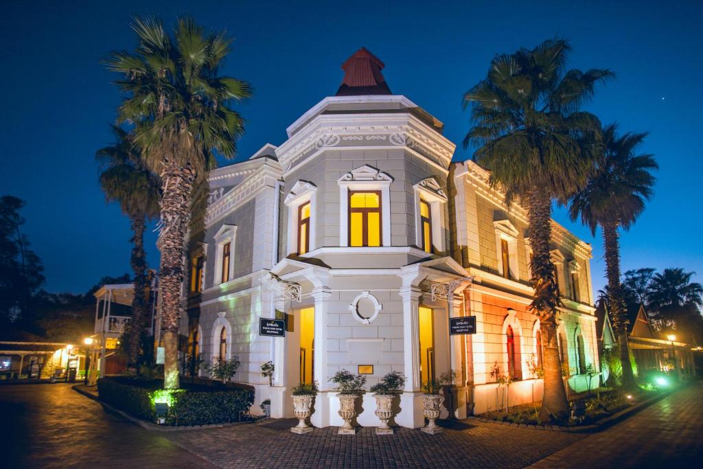 ヨハネスブルグにあるGold Reef City Theme Park Hotelのヤシの木が目の前に広がる白い建物