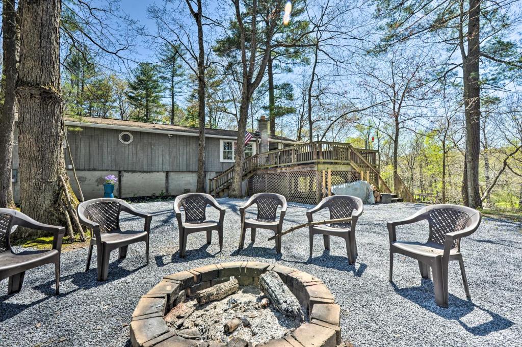 a group of chairs sitting around a fire pit at Cozy Cabin with Sunroom and Cacapon River Access! in Capon Bridge
