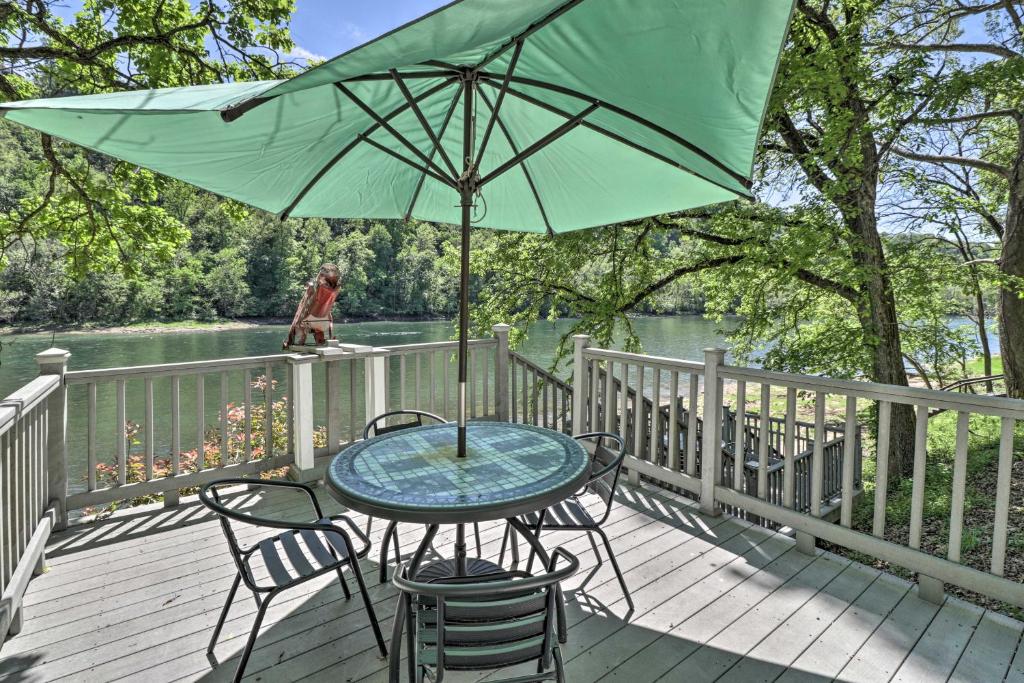 une table et des chaises avec un parasol vert sur une terrasse dans l'établissement Lakeview Escape with Direct White River Access!, à Lakeview