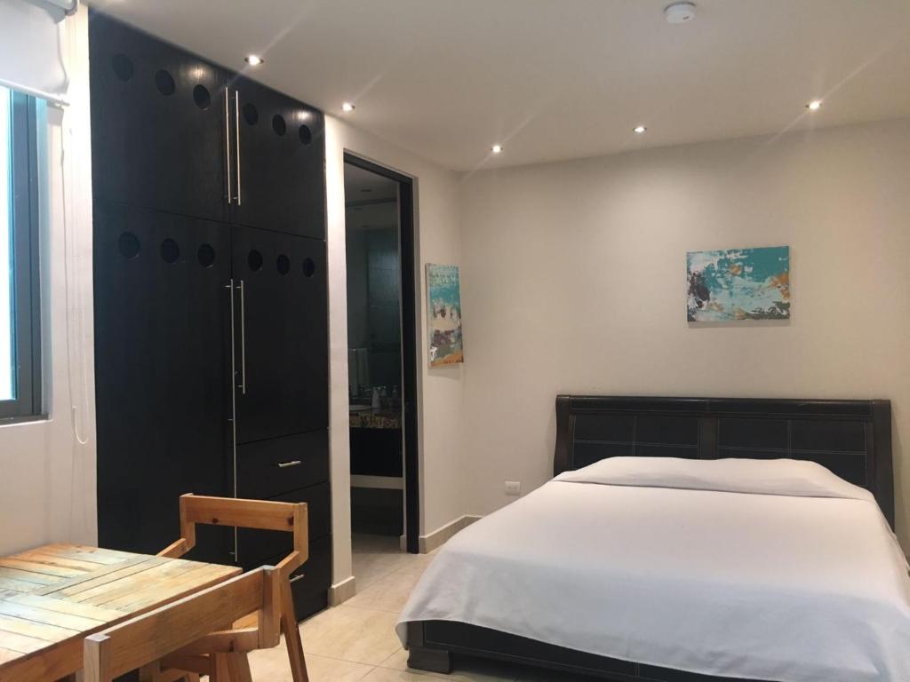 1 dormitorio con 1 cama grande y 1 mesa en Hotel 770, en Playa del Carmen