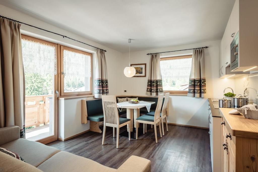 a kitchen and living room with a table and chairs at Residence Corn Le Tama in San Vigilio Di Marebbe