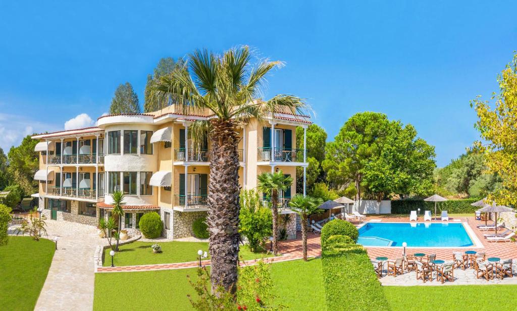 an exterior view of a large house with a swimming pool at Adani Hotel in Tsoukalades