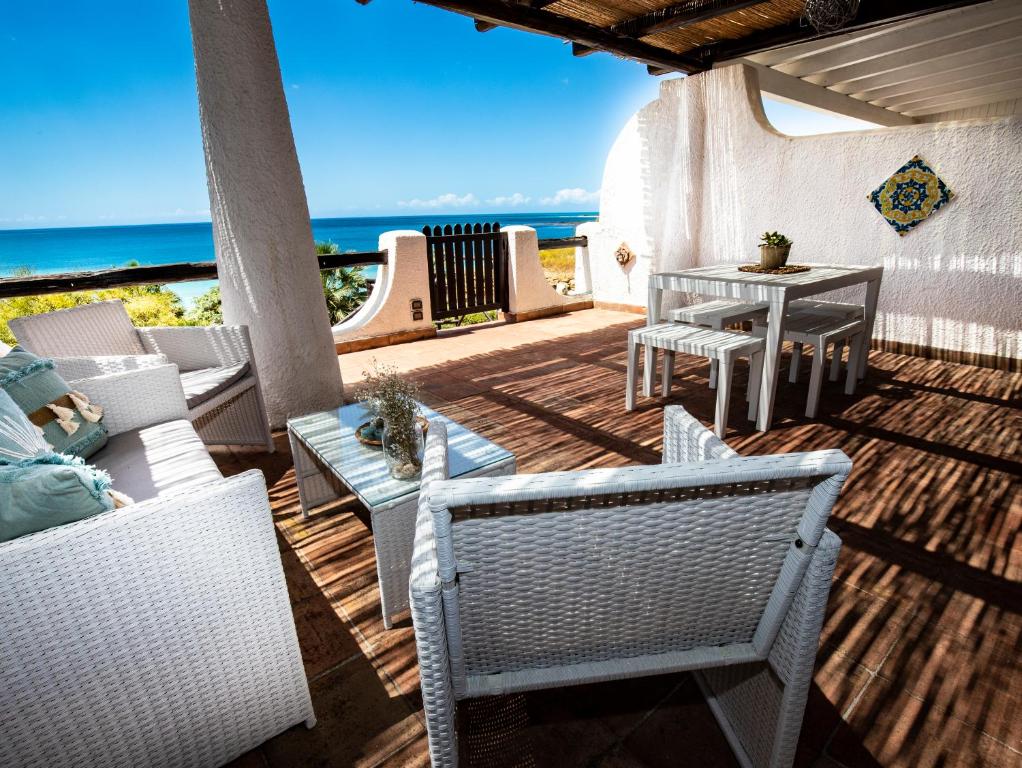 eine Terrasse mit Stühlen, einem Tisch und Meerblick in der Unterkunft Villa Sciacca Lumia in Sciacca