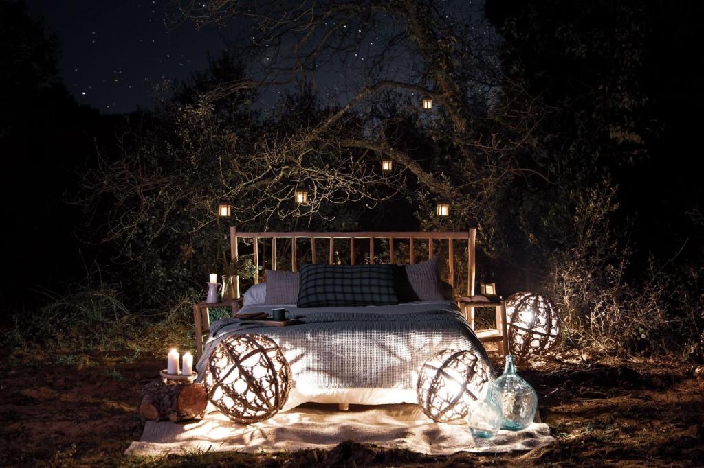 een bed bedekt met lichten in een tuin 's nachts bij Nits de Bosc in Vilassar de Dalt