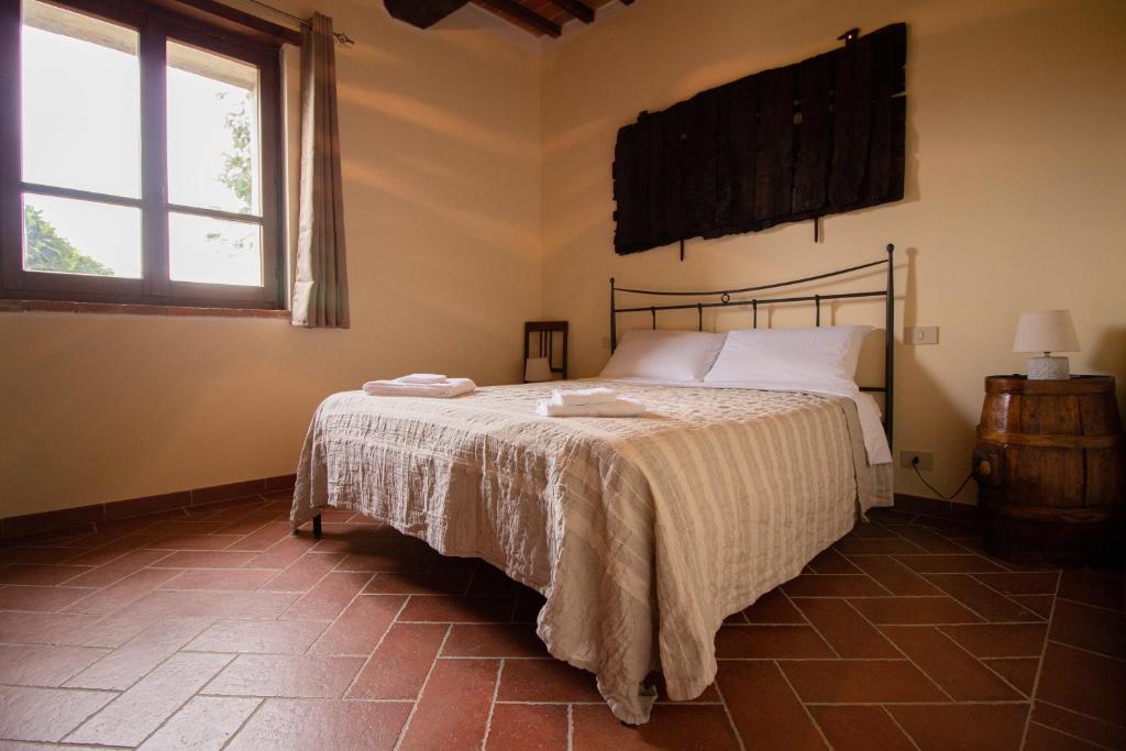 a bedroom with a bed and a window at Giglio Dorato in Castiglion Fiorentino