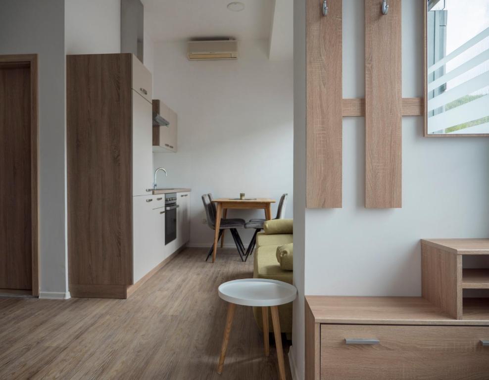 a kitchen and a living room with a table at Apartments Aura in Deskle