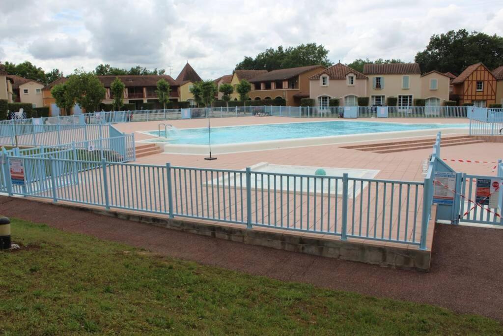 une piscine entourée d'une clôture bleue. dans l'établissement Résidence du Lac-MONFLANQUIN Appartement RDC, à Monflanquin
