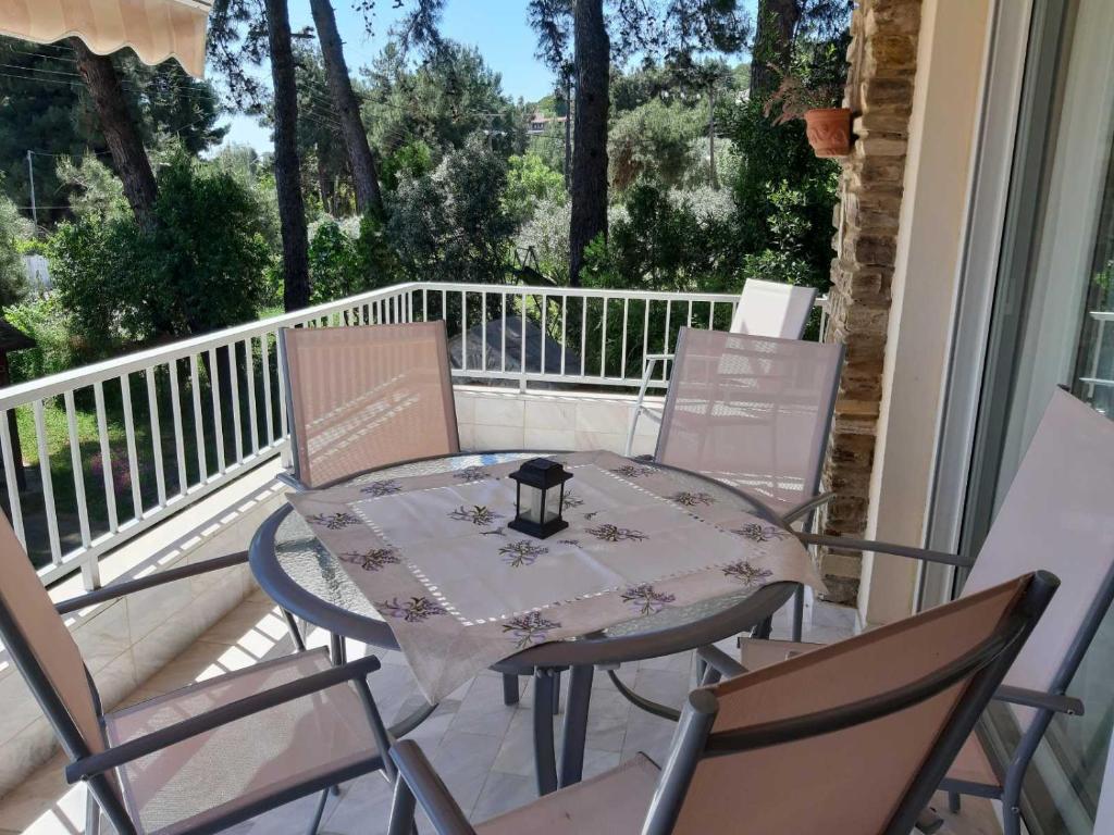 a table and four chairs on a porch with a table at Palio Villa in Paleo Tsifliki