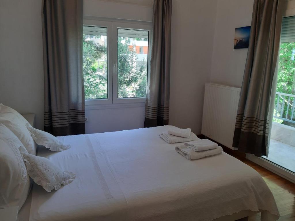 a bedroom with a white bed with two towels on it at Palio Villa in Paleo Tsifliki
