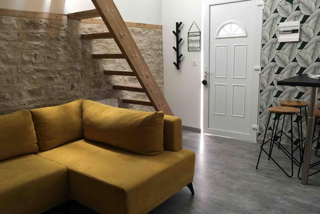 a living room with a couch and a staircase at Maison proche centre-ville in Dijon