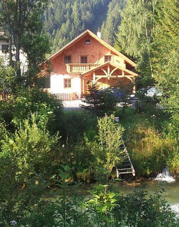 a house in the woods next to a river at Zimmer im Lungau in Sankt Michael im Lungau