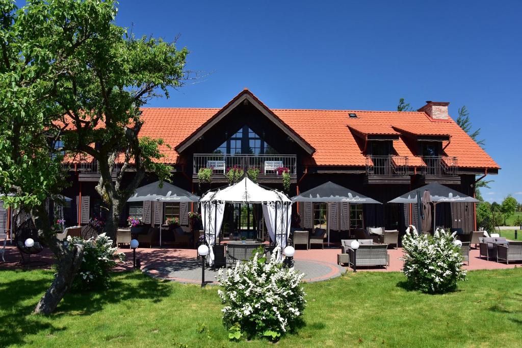 une grande maison avec un jardin en face de celle-ci dans l'établissement Rusne Villa, à Rusnė