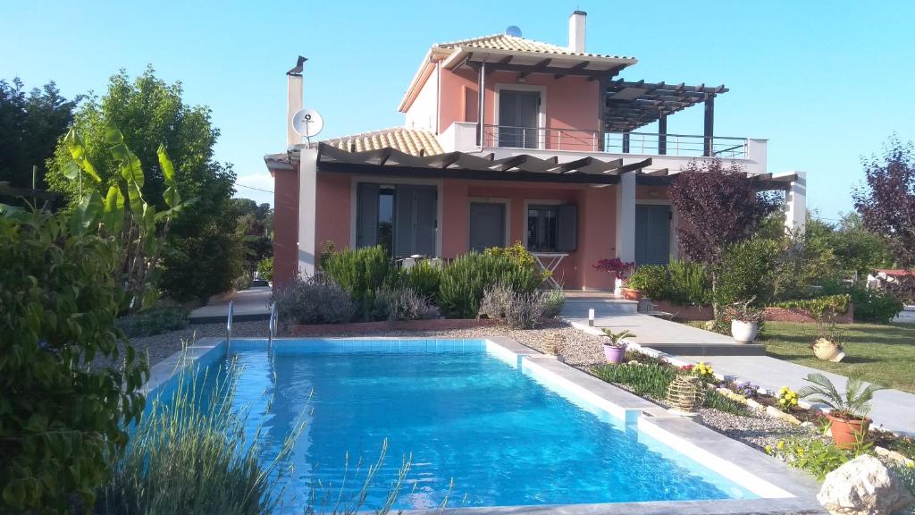a villa with a swimming pool in front of a house at The Moon House in Preveza
