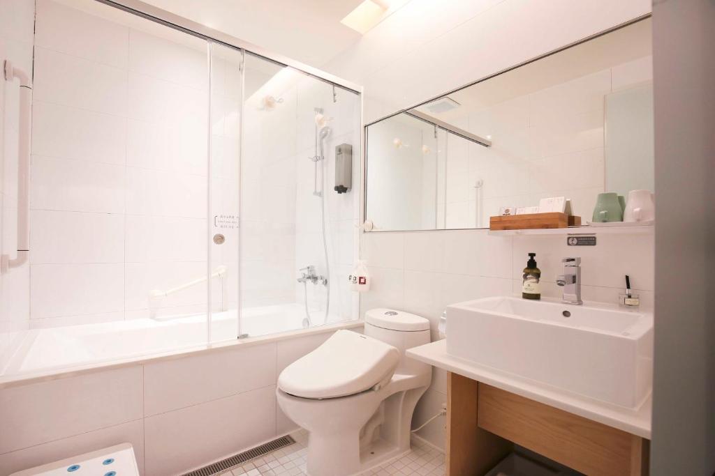 a white bathroom with a toilet and a sink at Dandy Hotel-Daan Park Branch in Taipei