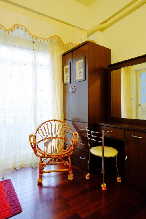 a room with a chair and a cabinet and a mirror at Fangyi Homestay in Ji&#39;an