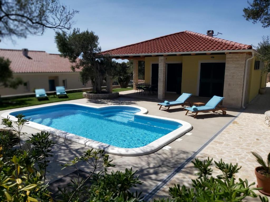 a swimming pool in front of a house at Villa Paula in Lun
