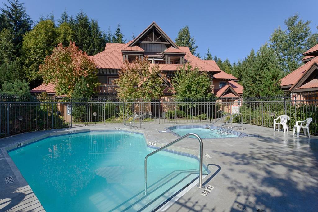 a large swimming pool in front of a house at Stoney Creek Sunpath by Whistler Premier in Whistler