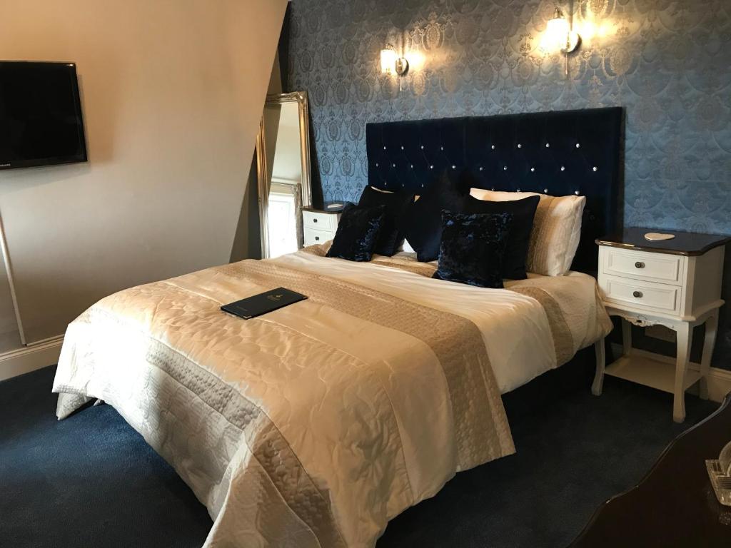 a hotel room with a large bed and a mirror at Norman Guest House with Free Parking in Whitby