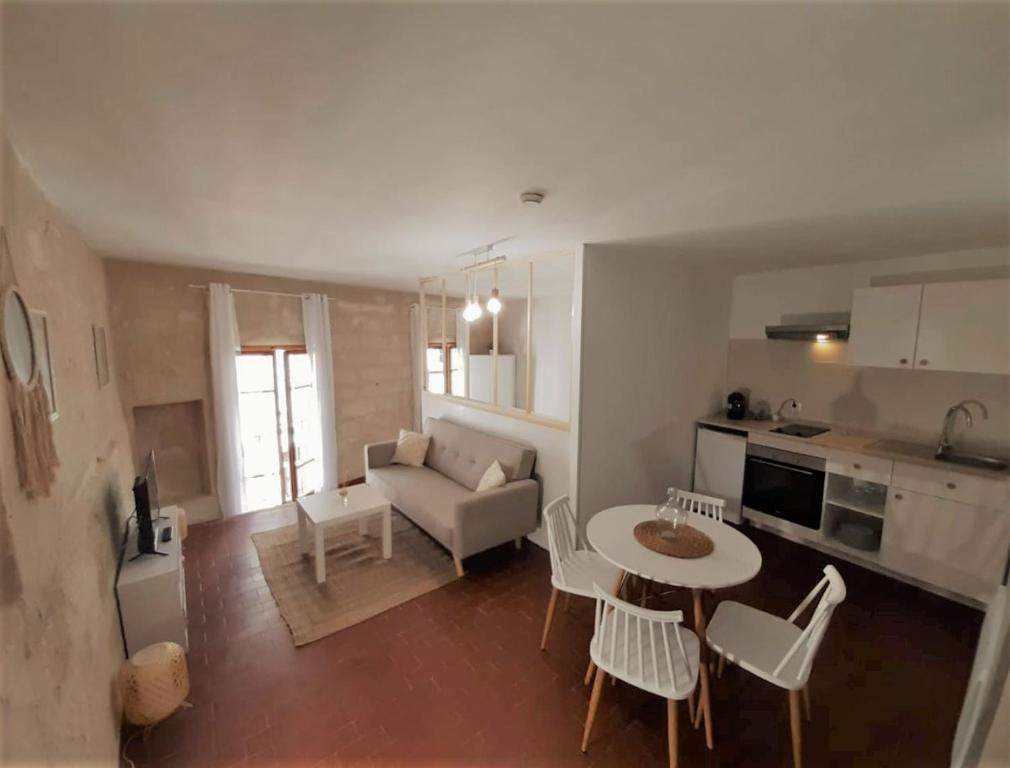 a kitchen and a living room with a table and chairs at Le Quatrième - Avignon Intramuros in Avignon