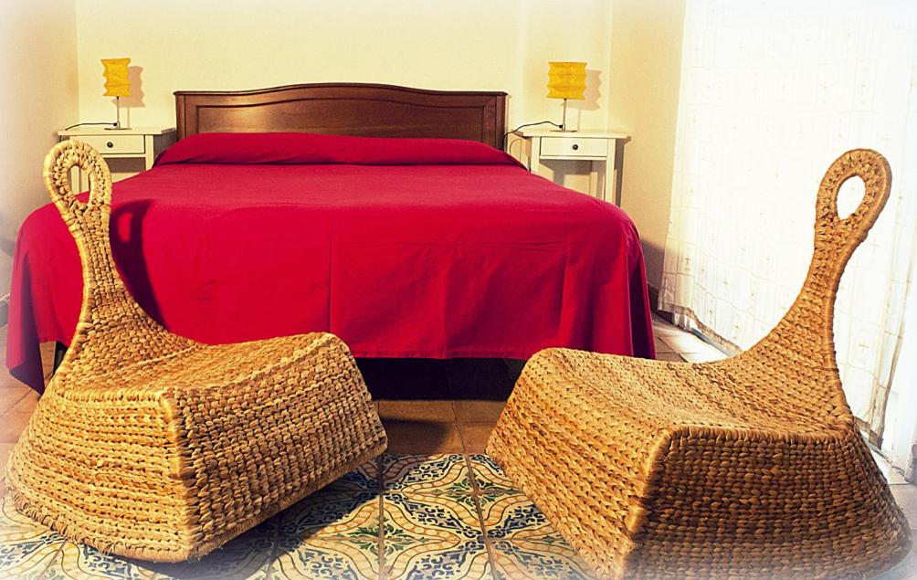 パレルモにあるOlivella Suite Ecological Houseのベッドルーム1室(ベッド1台、籐の椅子2脚付)
