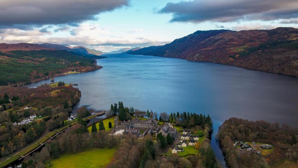 an aerial view of a house on the shore of a lake at Loch Ness Highland Resort in Fort Augustus