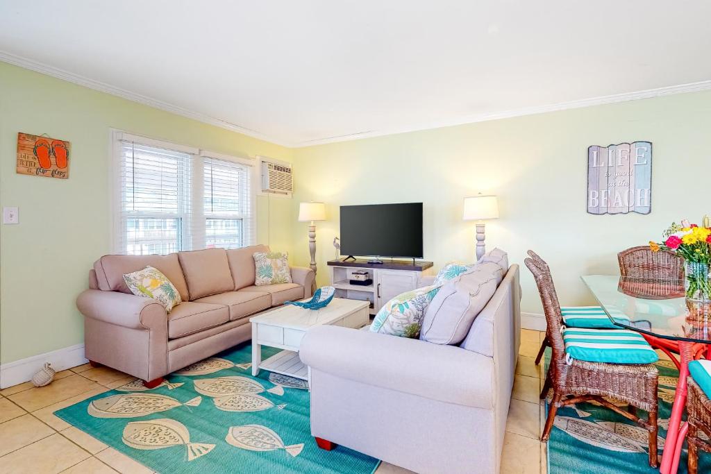 a living room with two couches and a table at Brooklyn's Casa Rosa & Hitch Apartment in Ocean City