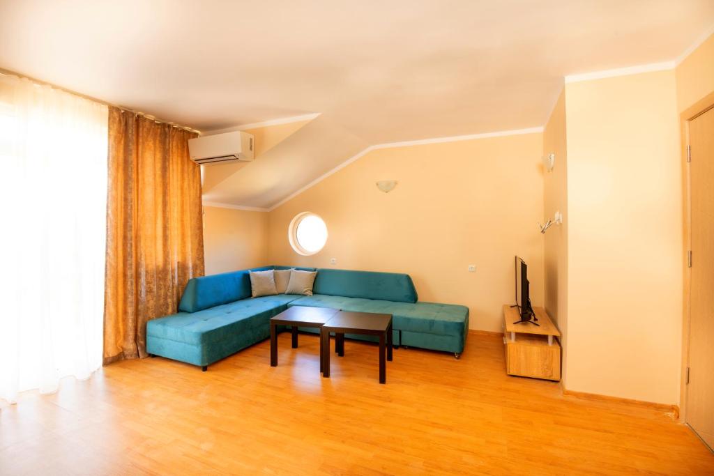 a living room with a blue couch and a table at House with Garden in Pomorie