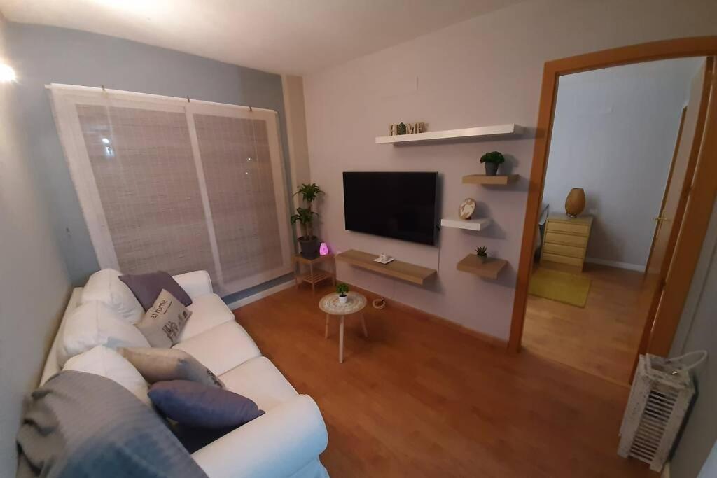 een woonkamer met een witte bank en een flatscreen-tv bij Apartamento moderno Timanfaya in Santa Cruz de Tenerife