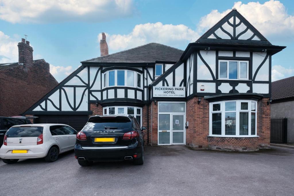 a house with two cars parked in front of it at The Pickering Park Hotel in Hull