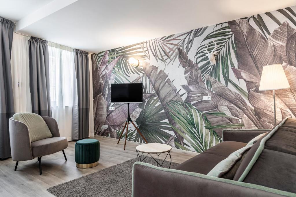 a living room with a large mural of leaves at Stay COOPER l Tivoli in Bolzano